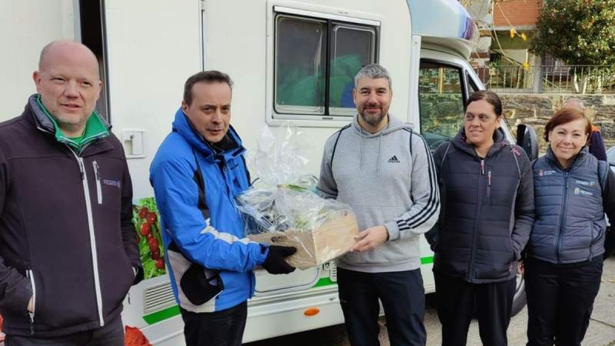 Carlos Fidalgo recibió una cesta de productos del Bierzo de la mano del alcalde de Vega de Espinareda, Javier Salgado, antes del comienzo de la ruta a primera hora del día en Burbia. DL