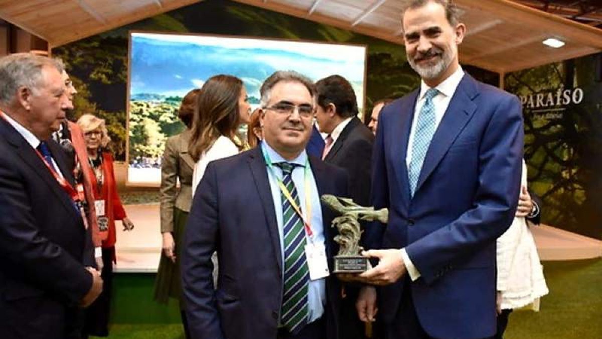 El pedáneo de San Facundo, Ricardo Vila, entregando a Don Felipe la escultura de la trucha. DL