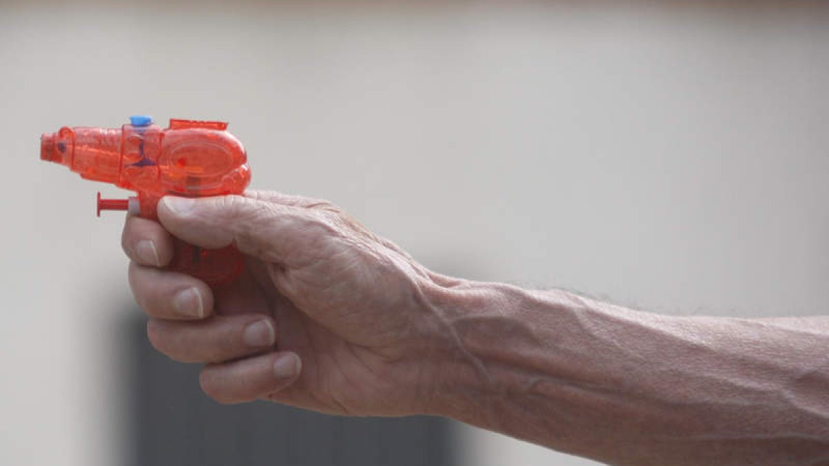 Un abuelo juega con la pistola de agua de su nieto. JESÚS F. SALVADORES