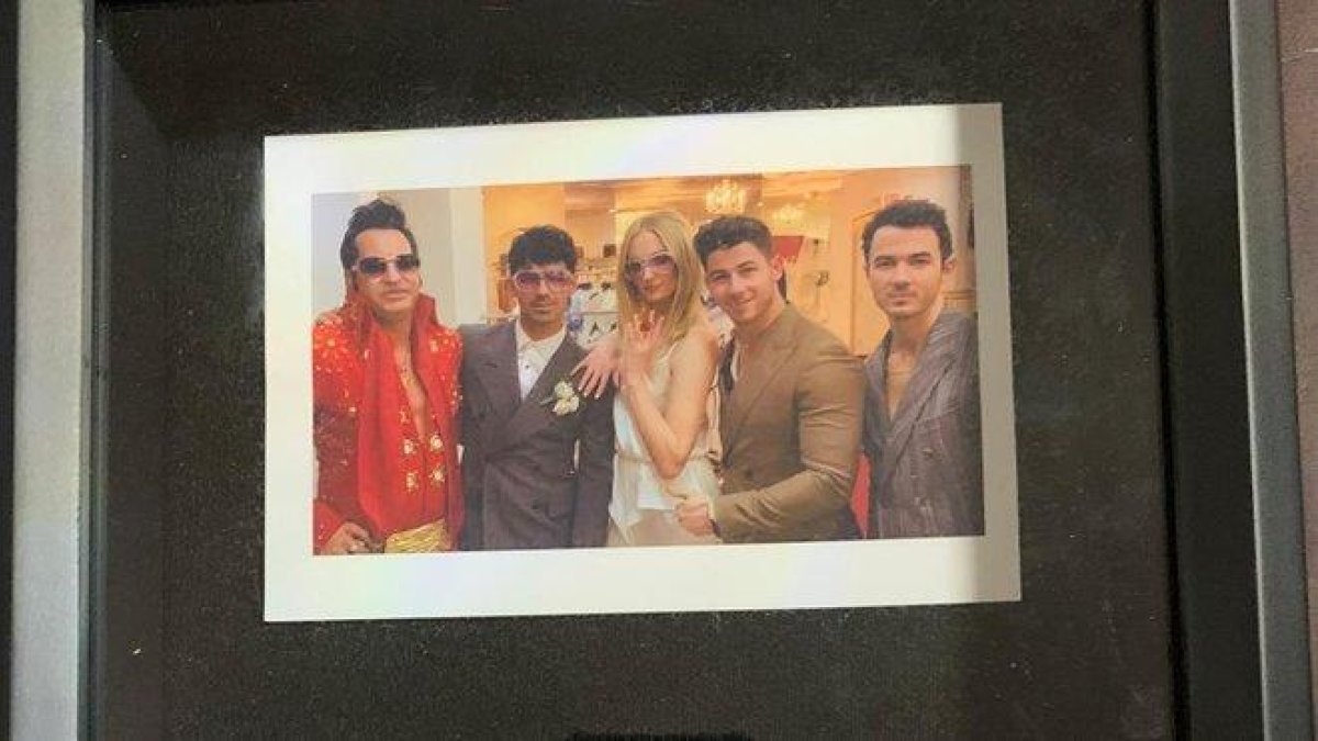 Detalle de la foto enmarcada de la boda de Joe Jonas y Sophie Turner, con el Elvis Presley que ofició la ceremonia y Kevin y Nick Jonas.