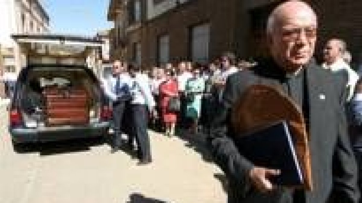 El secretario del cardenal en primer plano cuando sus familiares y amigos sacaban el féretro