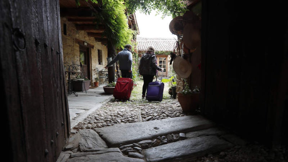 Dos viajeros acceden a la posada real Casa Pepa en Santa Colomba de Somoza. JESÚS F. SALVADORES