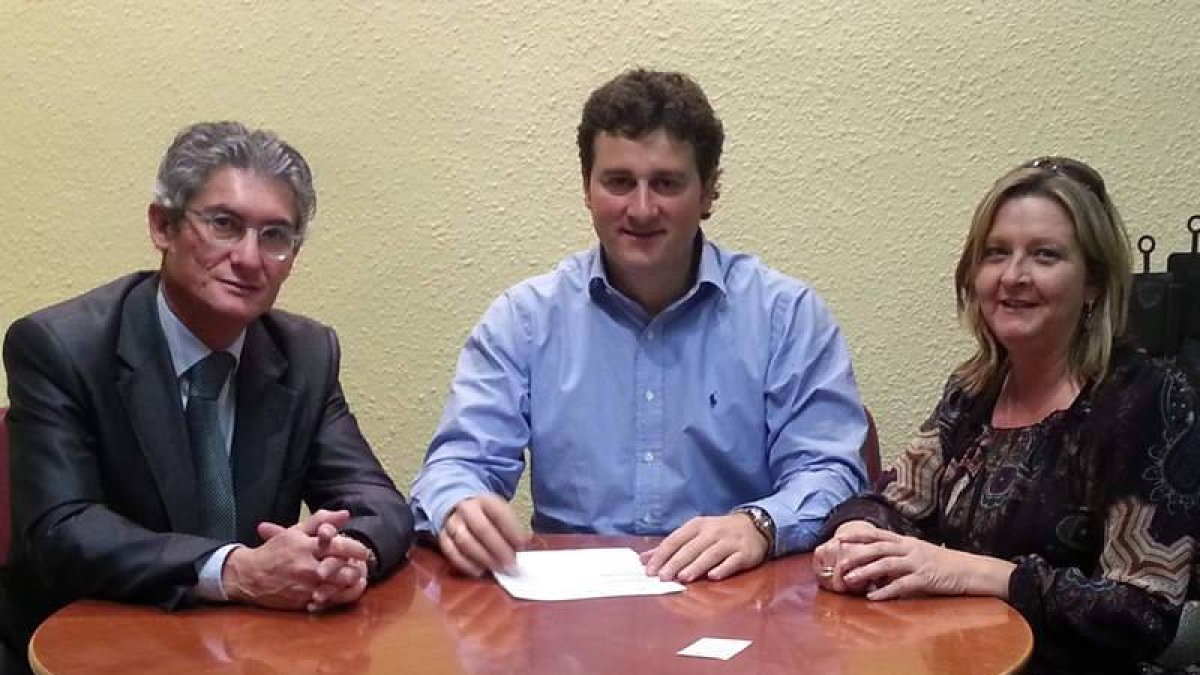 Firma del convenio entre el director de La Caixa y el alcalde, en presencia de la concejala de Mujer.