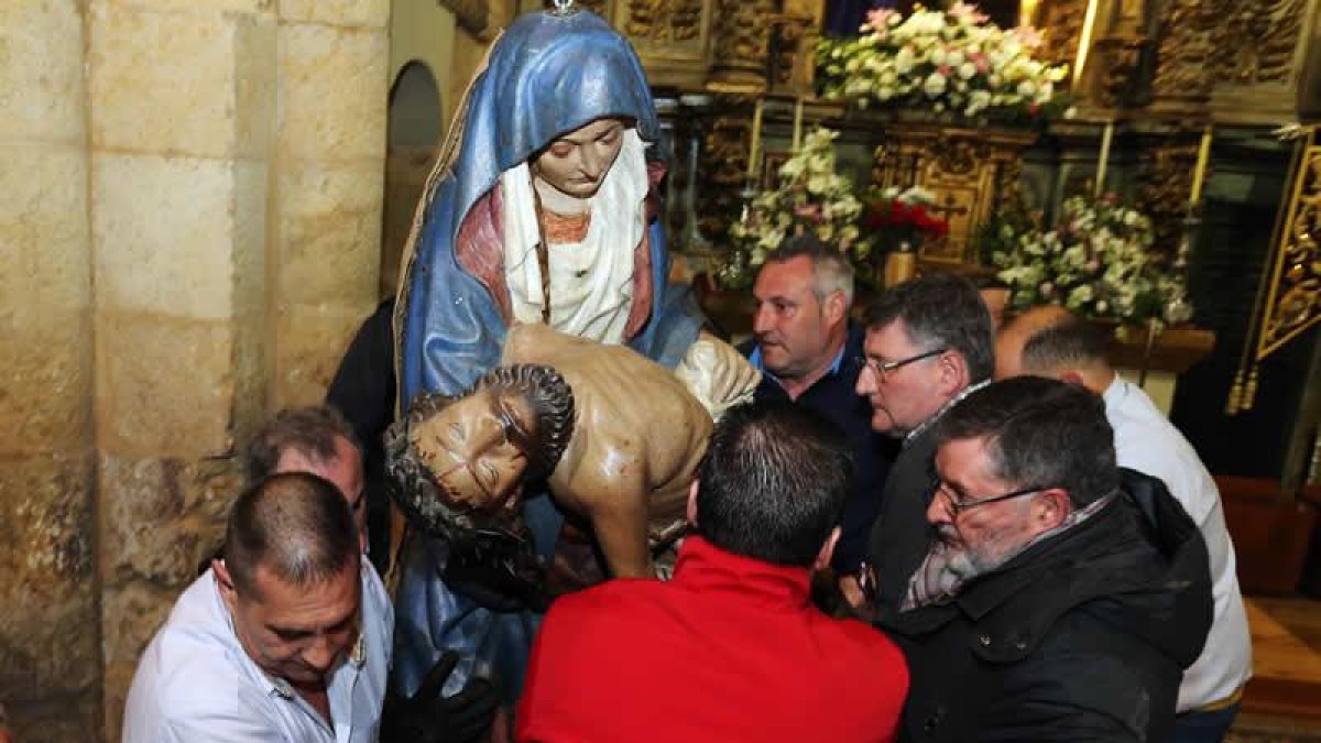 Los camareros de la Virgen del Mercado descienden la talla de la Piedad para prepararla para la inmemorial procesión de la Dolorosa de hoy.