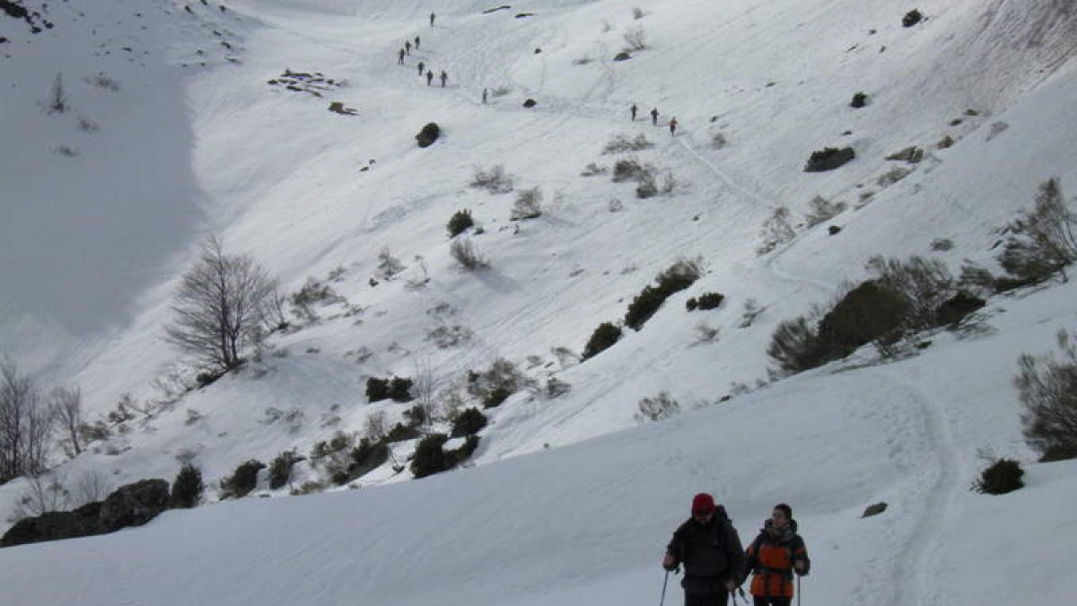 Dos de los raquetistas, durante la travesía, seguidos, al fondo, por otros participantes.