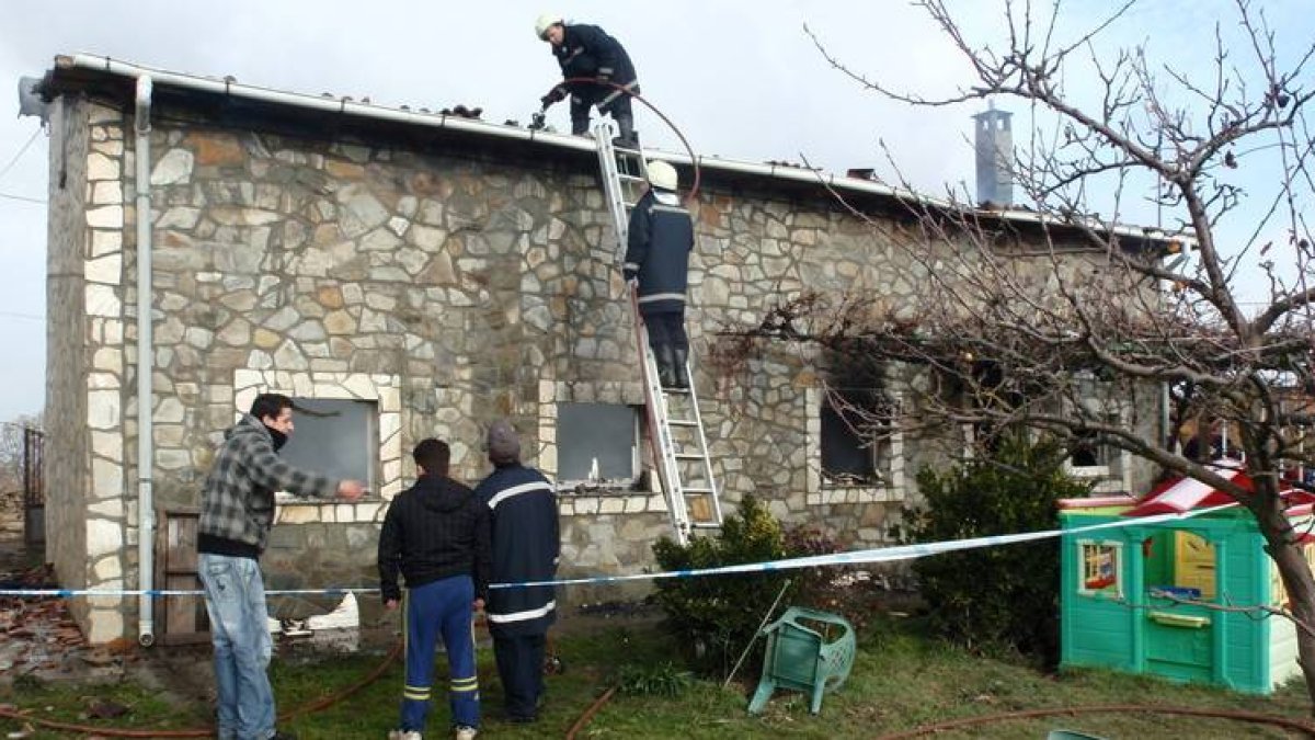 Los bomberos voluntarios de Astorga realizan labores para sofocar y controlar el fuego en la vivienda.