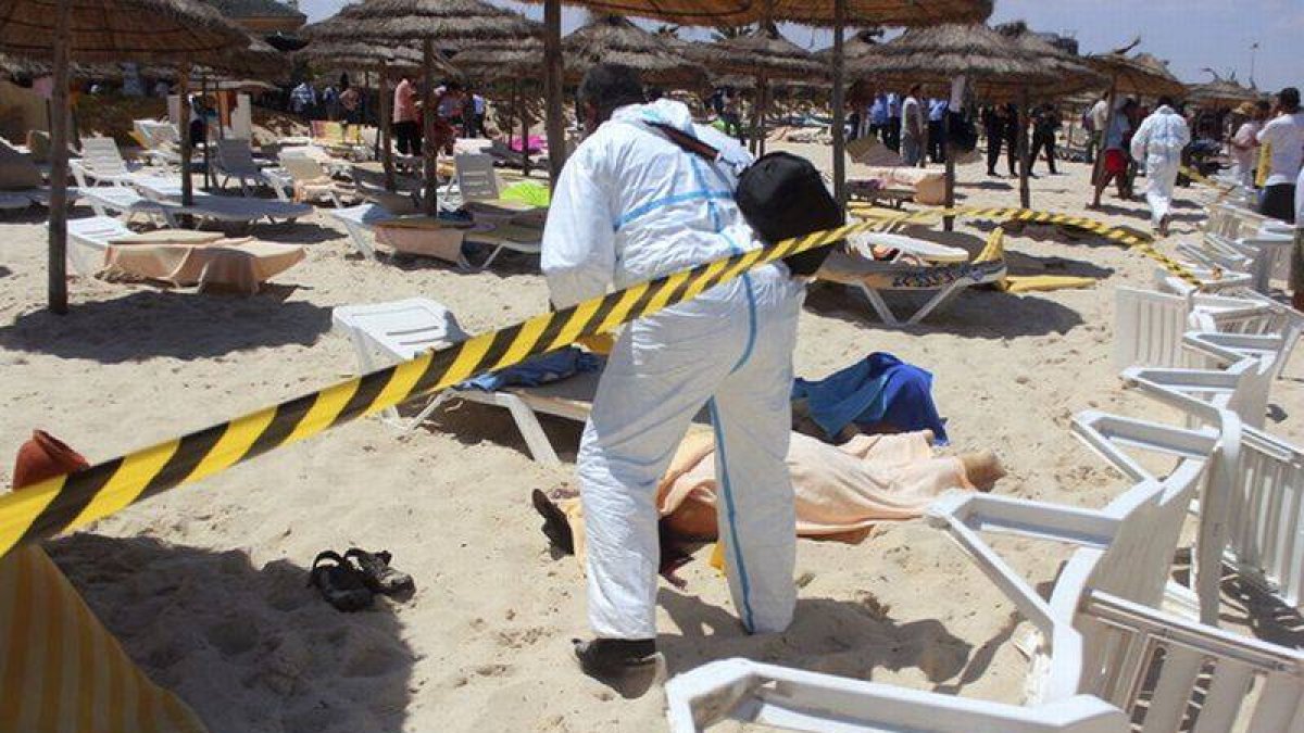 Un policía examina a dos víctimas del ataque terrorista en uno de los hoteles de Susa, en Túnez, el pasado 26 de junio.
