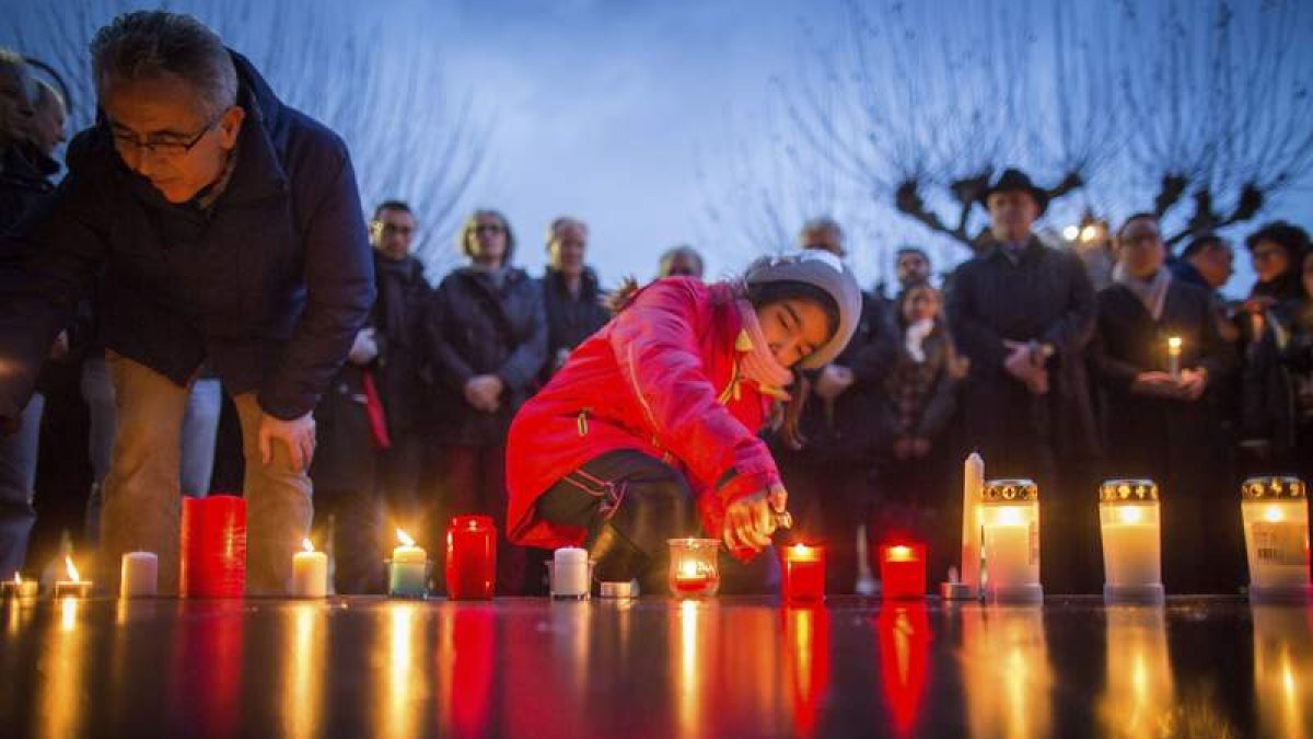 El parlamentario del SPD Yüksel y una niña encienden velas en homenaje a las víctimas.