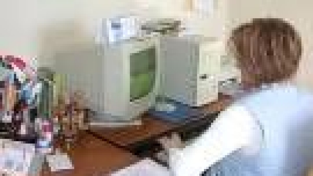 Una vecina utiliza un ordenador en la localidad de Las Omañas