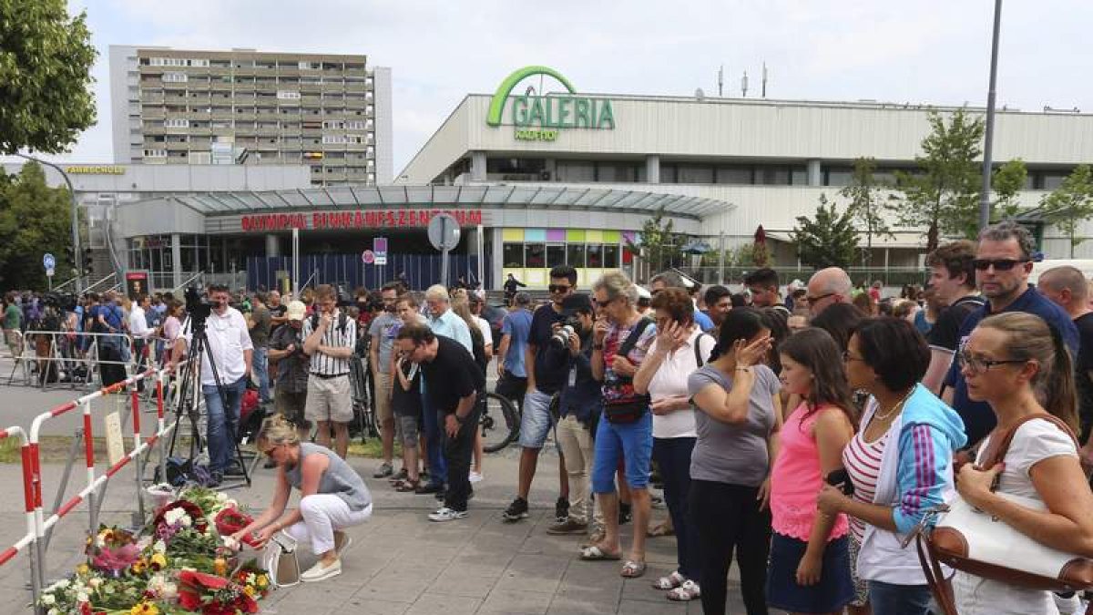 Los ciudadanos depositan flores junto al centro comercial. KARL-JOSEF HILDENBRAND
