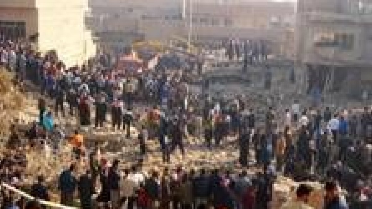 Decenas de iraquíes se agolpan frente al lugar donde cayó derrumbado el edificio en Bagdad