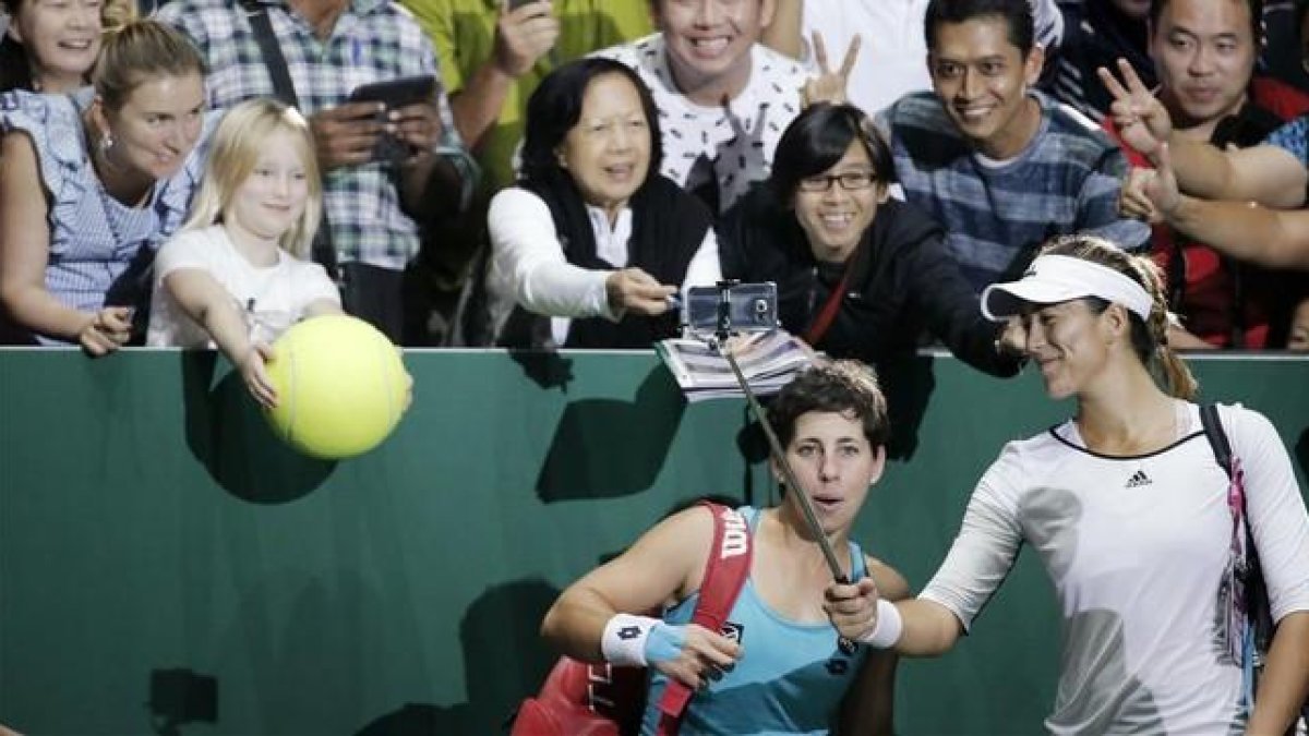 Garbiñe Muguruza y Carla Suárez celebrando su victoria junto a los aficionados presentes en Singapur