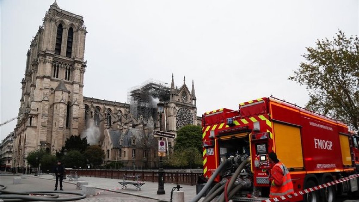 Bomberos ante Notre Dame, tras extinguir las llamas.
