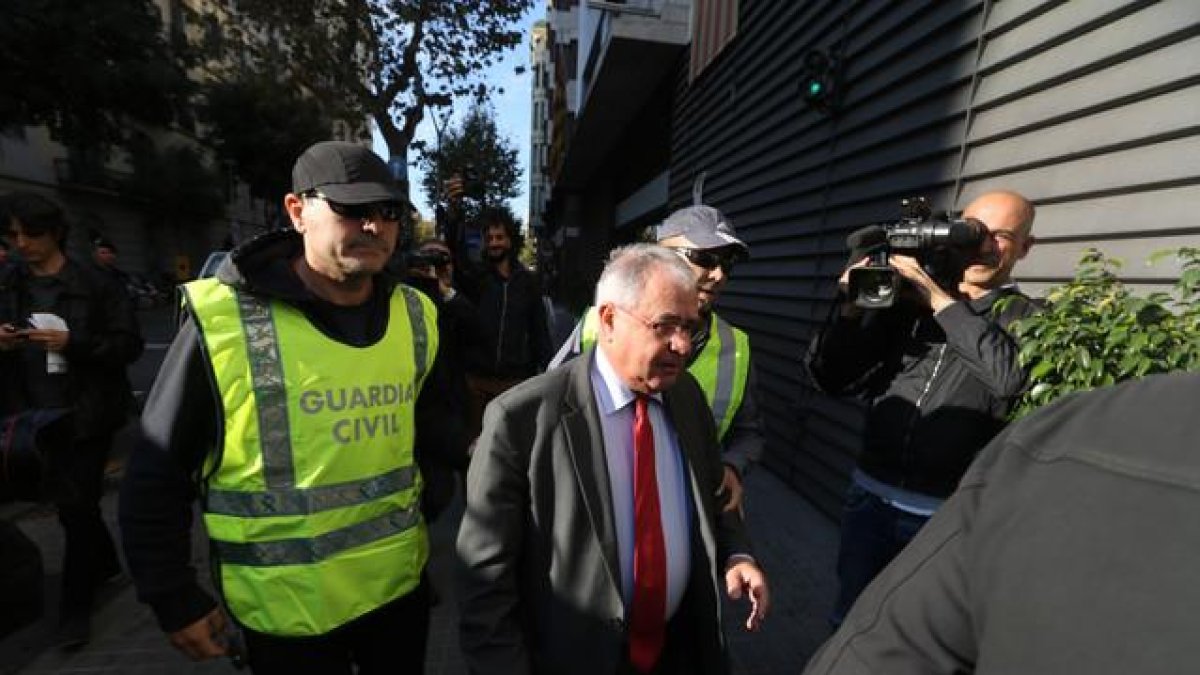 El tesorero de CDC, Andreu Viloca, a su entrada en la sede del partido, escotado por agentes de la Guardia Civil.