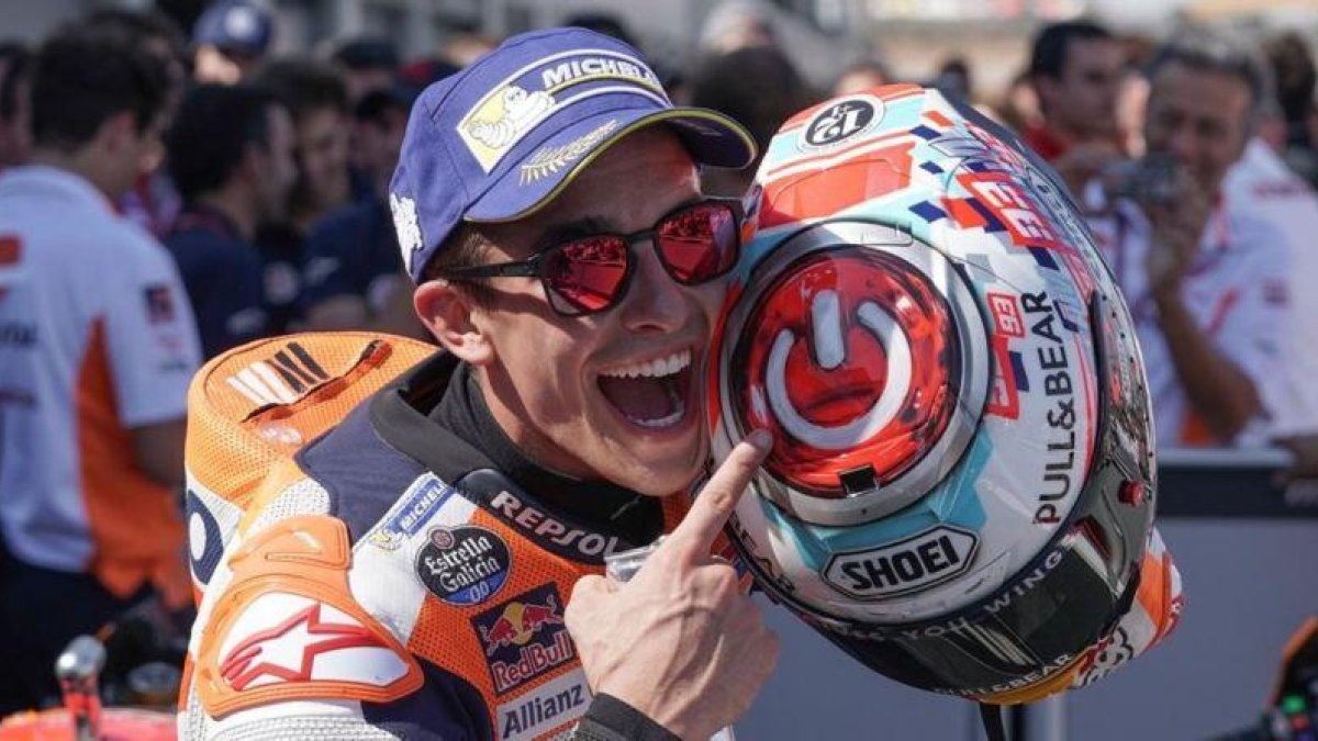 Marc Márquez señala, feliz, el interruptor que tiene dibujado sobre su casco.