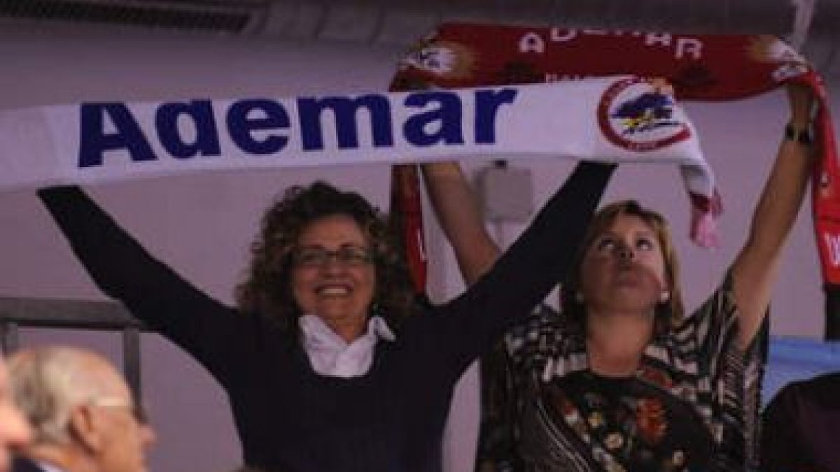 Dos aficionadas hacen ondear banderas del Reale Ademar durante un partido.