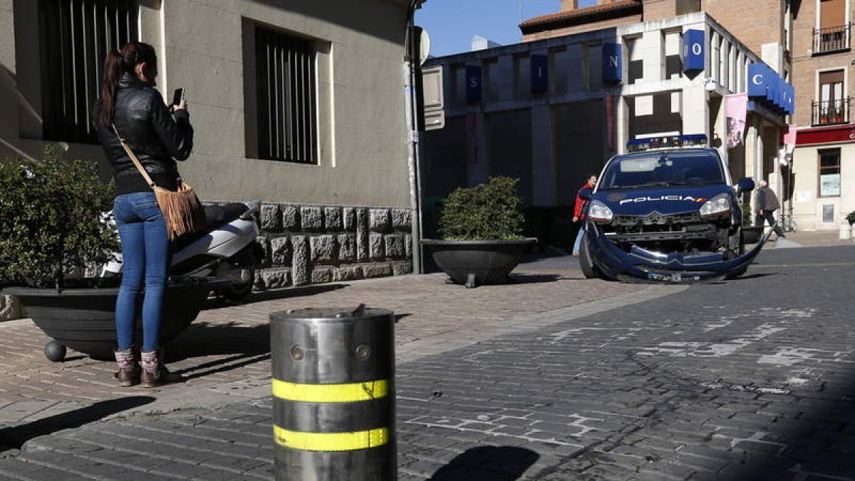 El coche de la Policía Nacional resultó dañado por la subida del bolardo.