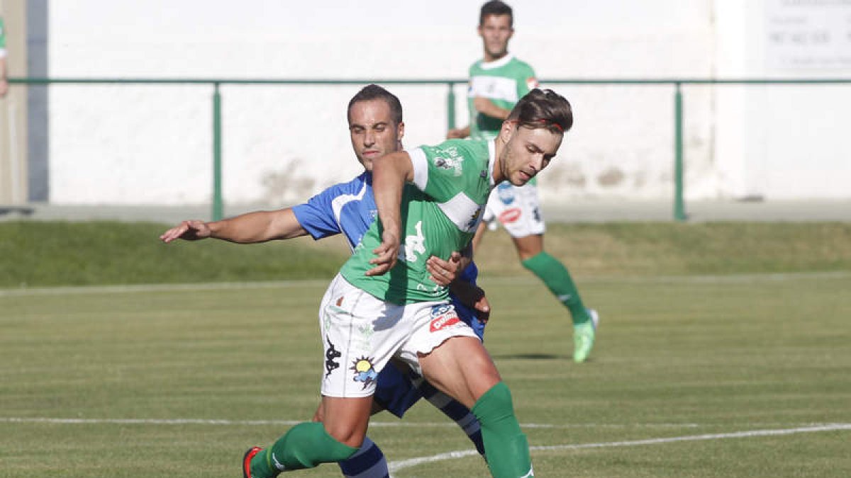 Cristian se lleva un balón colgado por los segovianos evitando que llegue a Quique.