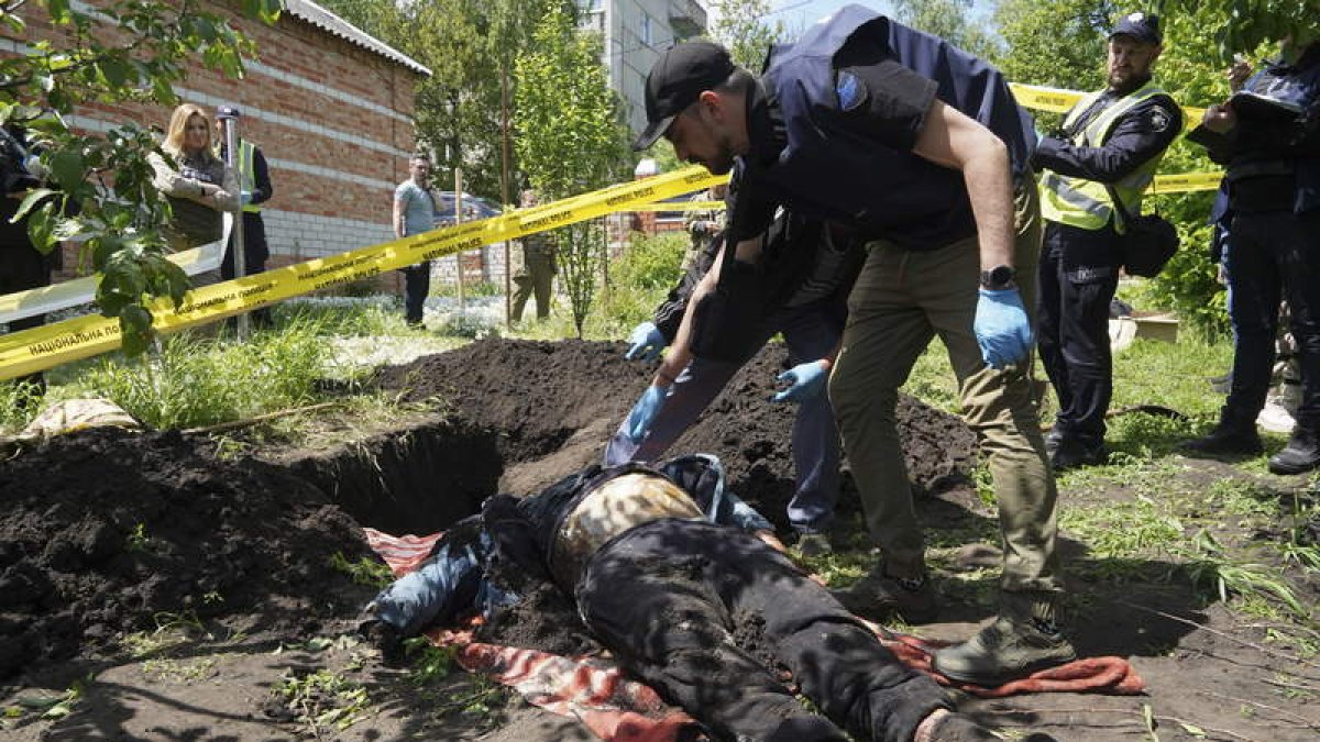 Un soldado ucraniano saca de una zanja el cadáver de un civil asesinado en la ciudad de Járkov. VASILIY ZHLOBSKY