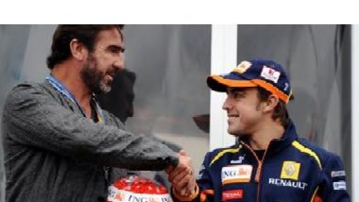 Alonso con el futbolista Eric Cantoná, en el photocall del circuito de Silverstone, hoy