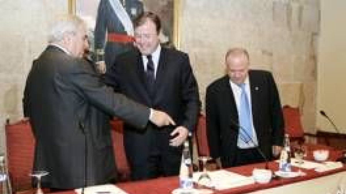El consejero de Fomento, Antonio Silván, saluda a Enrique Múgica en presencia de Javier Amoedo