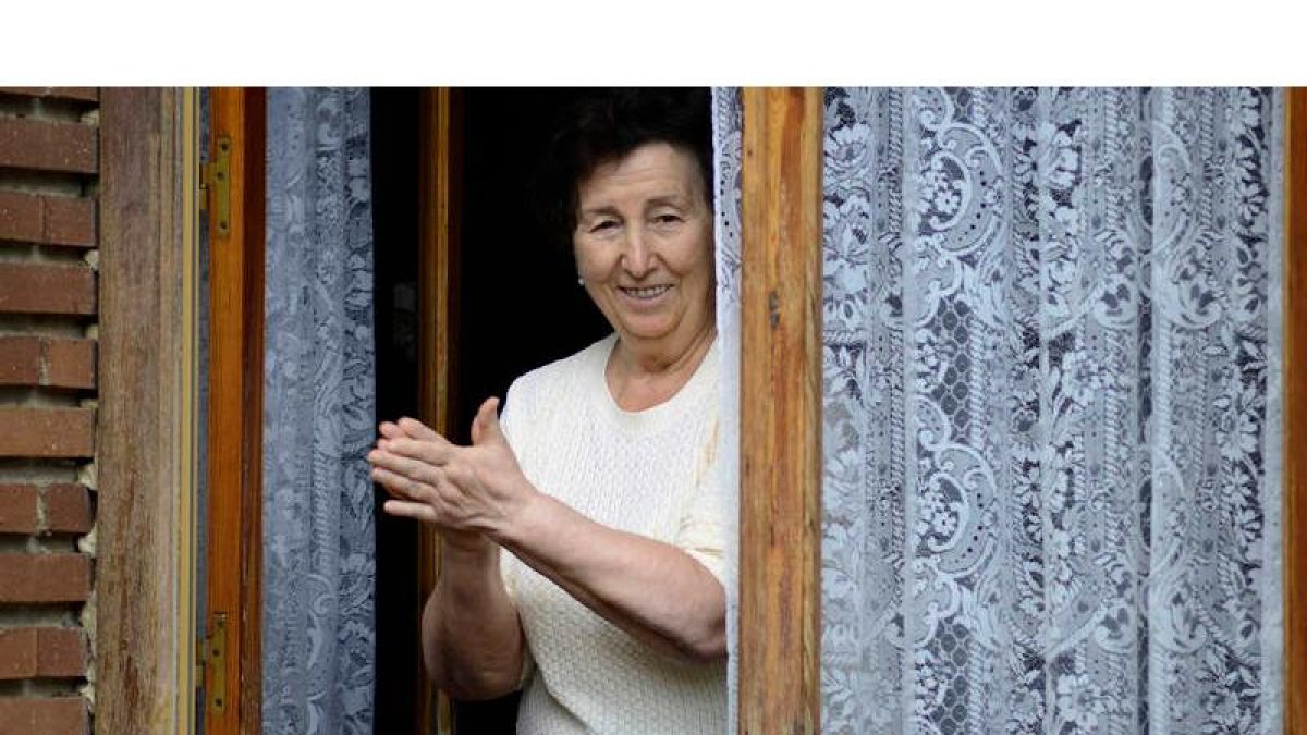 Una vecina de Sahagún sale fiel a su ventana a las ocho de la tarde a rendir homenaje a los sanitarios. ACACIO DÍAZ