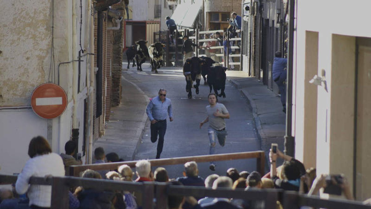 Dos mozos inician la carrera ante la manada en la calle Alhóndiga. ACACIO