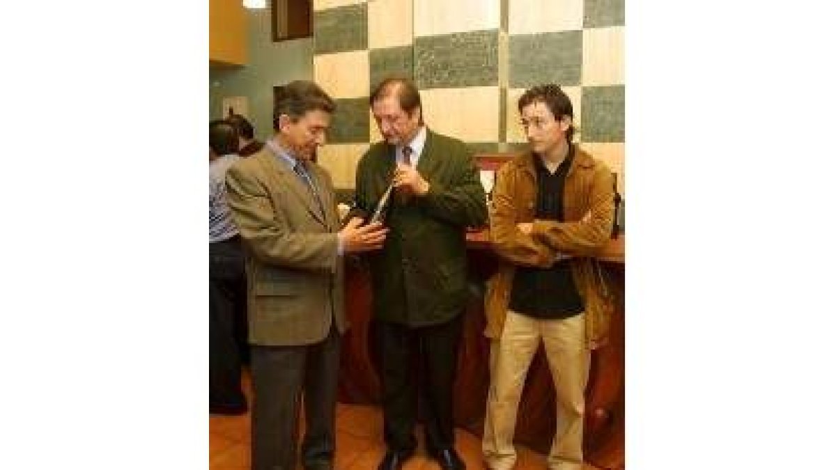 Los responsables de la bodega muestran el vino al alcalde