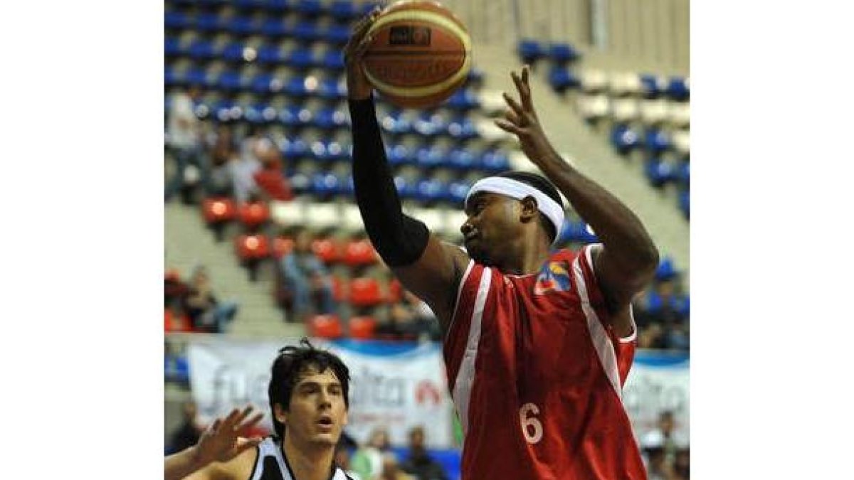 Rick Hughes, de nuevo destacado, atrapa un balón con autoridad ante un rival isleño.
