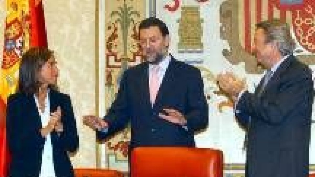 Ana Mato y Luis de Grandes aplauden a su secretario general, Mariano Rajoy, al finalizar su discurso