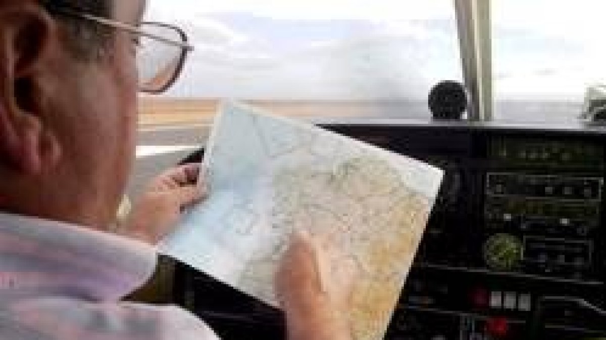 Un piloto consulta una carta aeronáutica en uno de los aviones del Aero Club de León