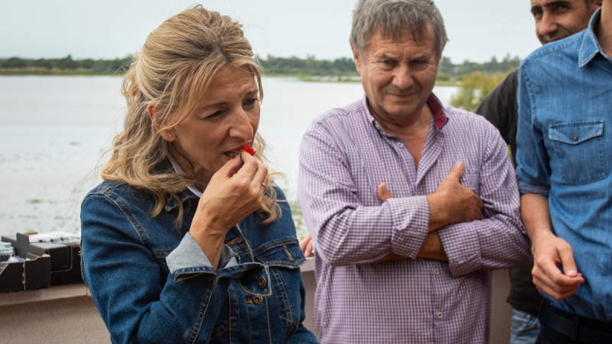 Yolanda Díaz prueba una de las fresas que le han ofrecido algunos de los agricultores de la aldea del Rocío. JULIÁN PÉREZ