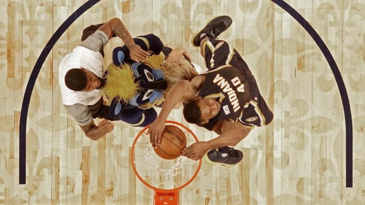 Glenn Robinson III salta por encima de Paul George (2,06), la mascota de los Pacers y una animadora del equipo para ganar el concurso de mates del All Star de Nueva Orleans.