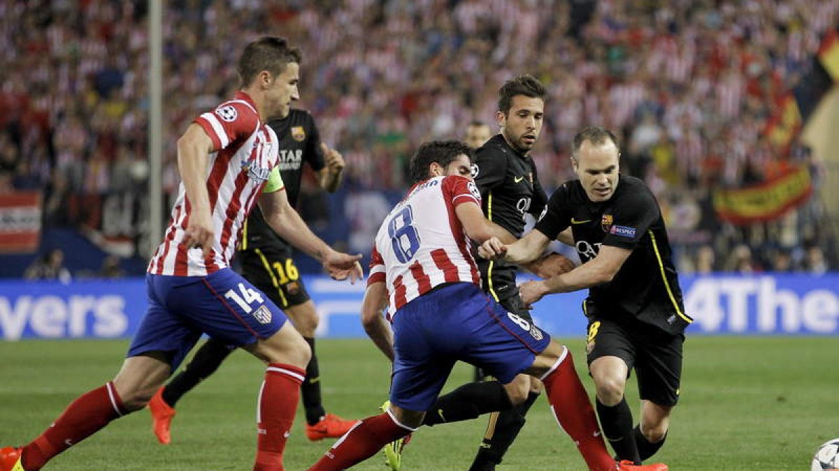 Iniesta, a la derecha, trata de llevarse el balón en un duelo entre el Barça y el Atlético.