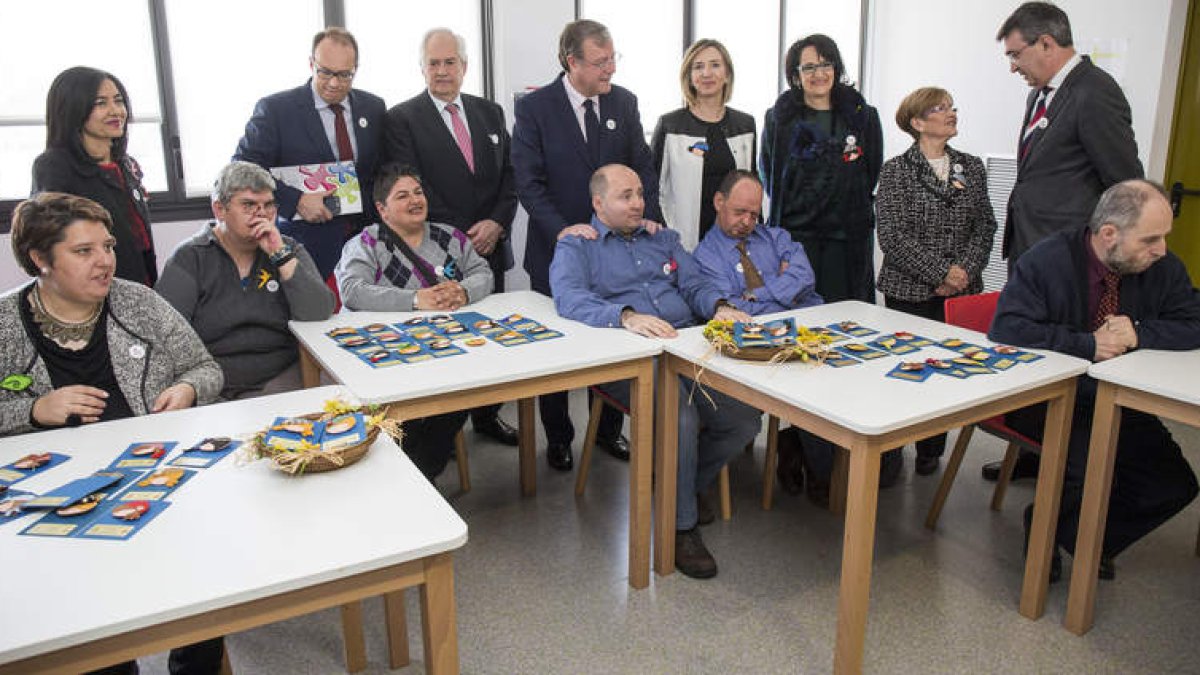 Autoridades participantes en la inauguración junto a un grupo de personas que realizan trabajos manuales. FERNANDO OTERO PERANDONES
