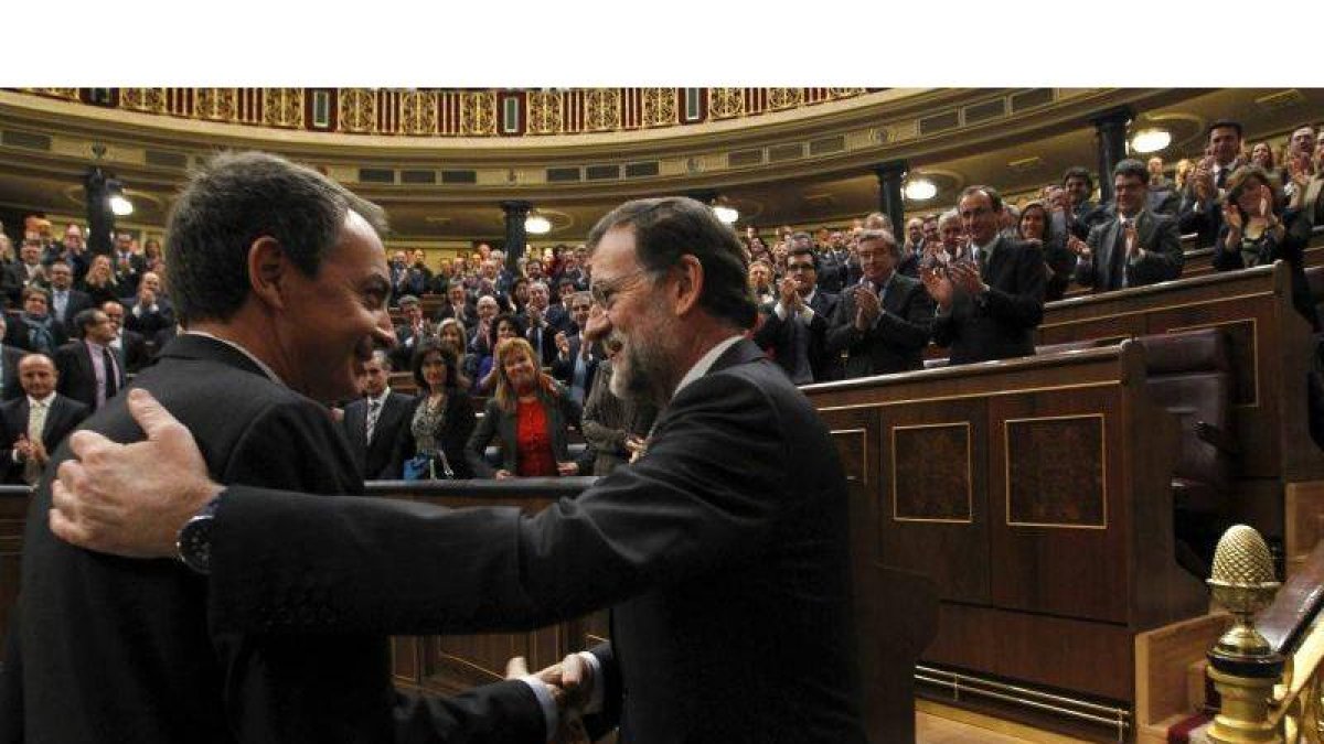 El jefe del Ejecutivo saliente, José Luis Rodríguez Zapatero (i), felicita al líder del PP, Mariano Rajoy, tras ser elegido presidente del Gobierno.
