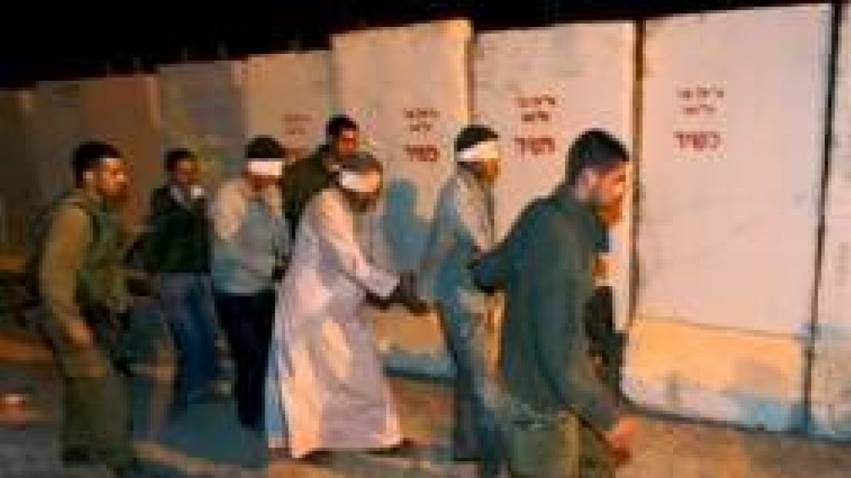Varios soldados israelíes llevan detenidos a varios militantes palestinos detenidos en la operación