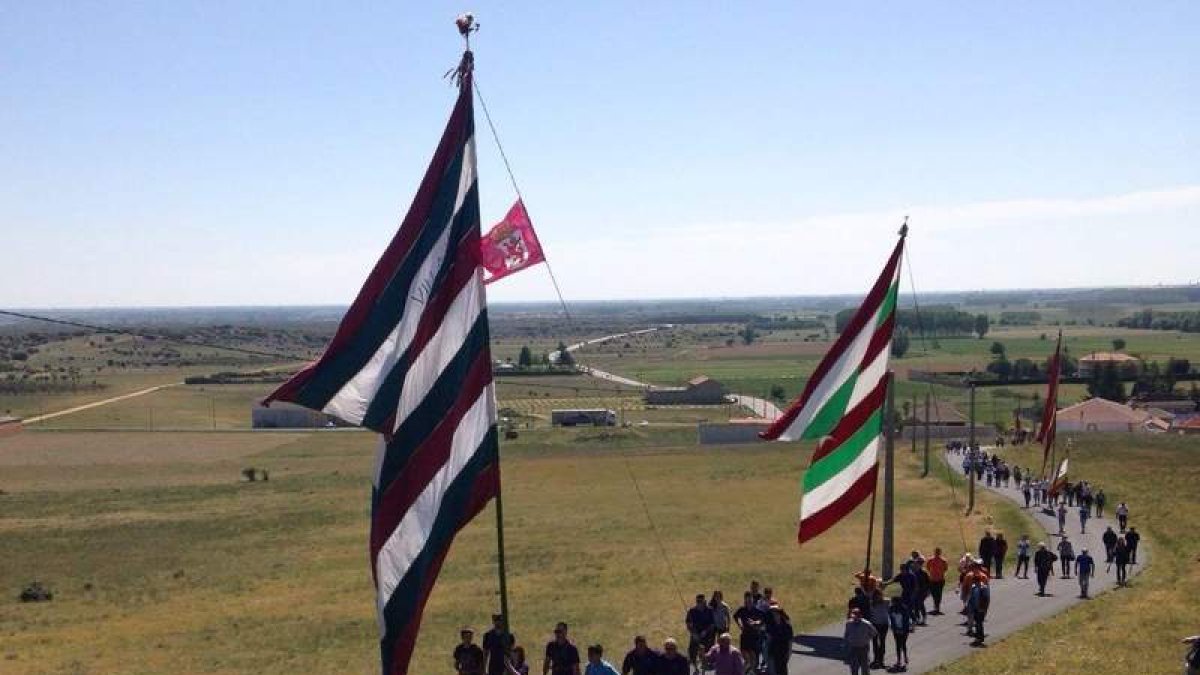 Los pendones de La Valduerna junto a las tallas y las cruces suben al santuario.