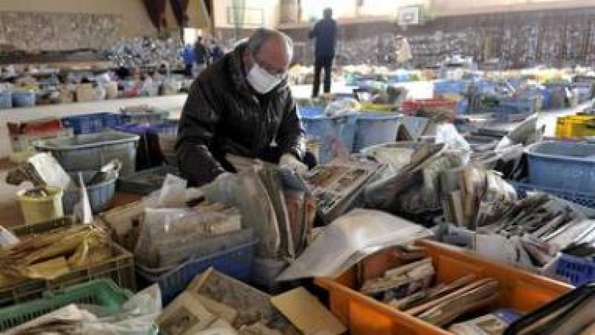 Un superviviente del tsunami busca sus pertenencias entre los objetos rescatados.