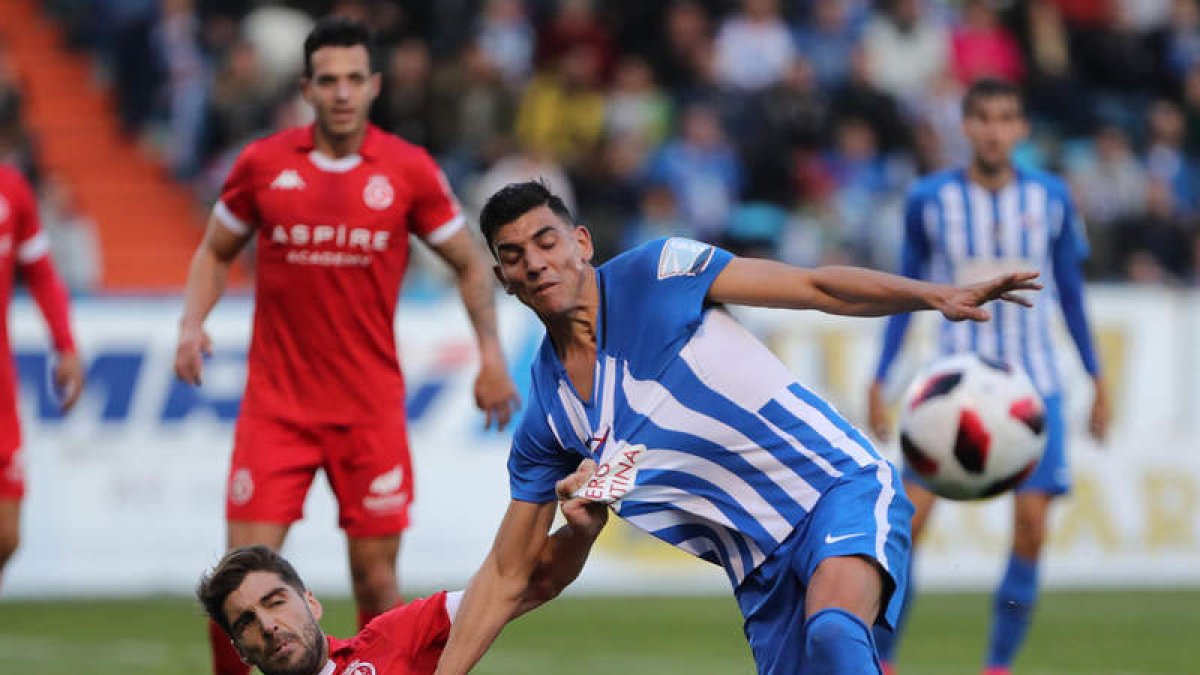 Iván González sujeta por la camiseta al delantero de la Ponferradina David Grande. L. DE LA MATA/MARCIANO PÉREZ
