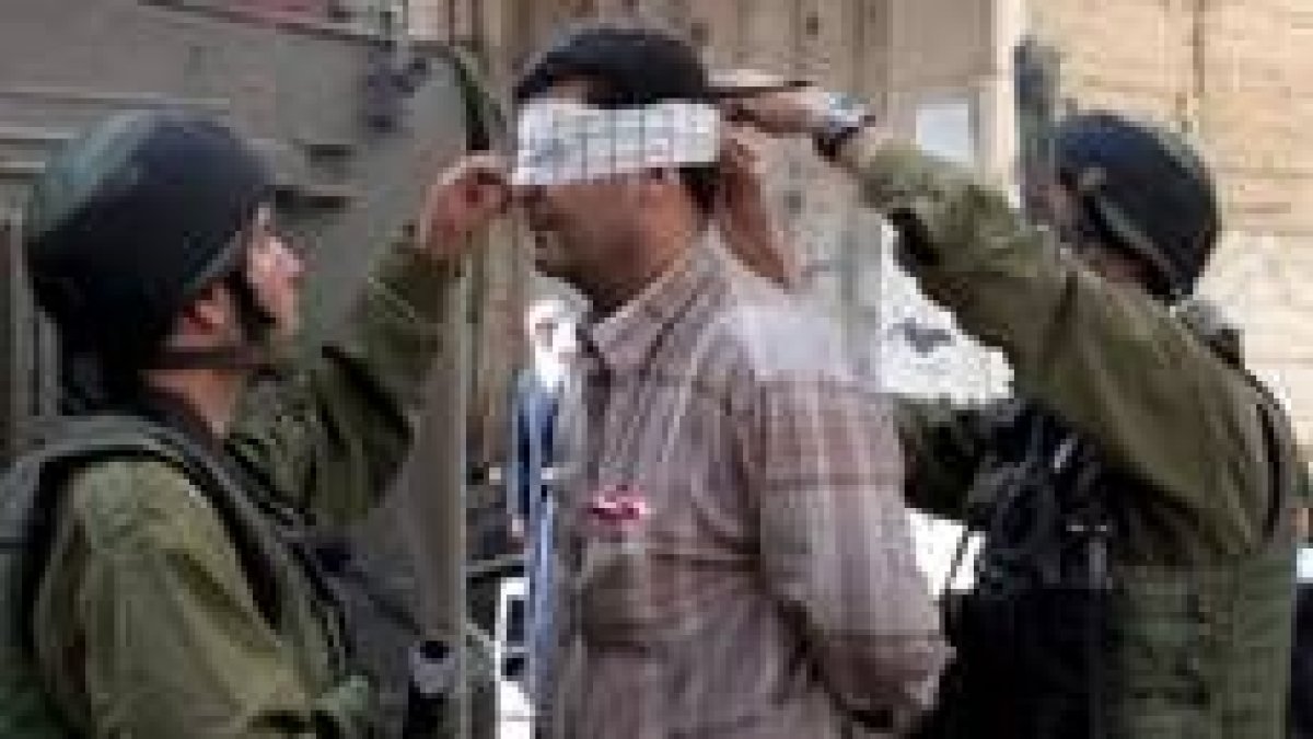 Unos soldados israelíes detienen a un supuesto miembro de Hamás