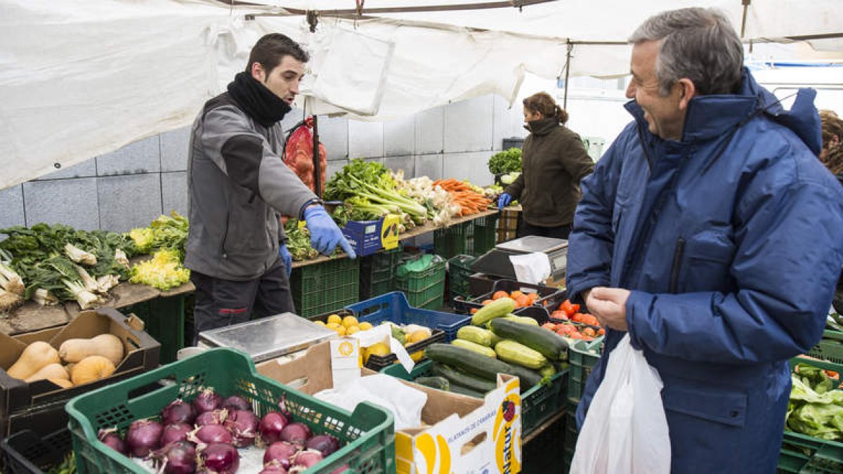 Alejandro Bernal señala los calabacines, entre la oferta de producción propia que lleva semanalmente a su puesto del mercado de Colón. F. OTERO PERANDONES