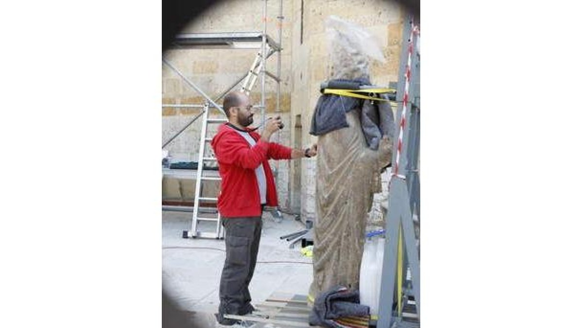 Momento en el que los operarios apean la estatua de san Pedro.