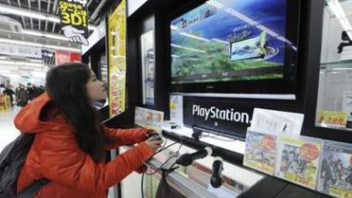 Una joven prueba la videoconsola de Playstation en un gran almacén.