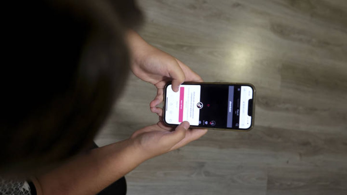Una persona consulta su teléfono móvil, J. M. GARCÍA
