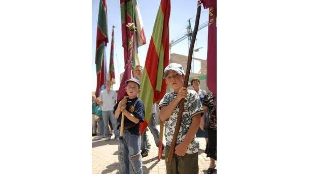 Dos niños sujetan un pendón en la Octava de Sariegos.