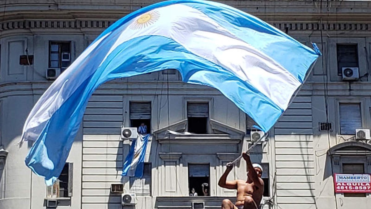 Un hombre subido a un semáforo. AGENCIAS