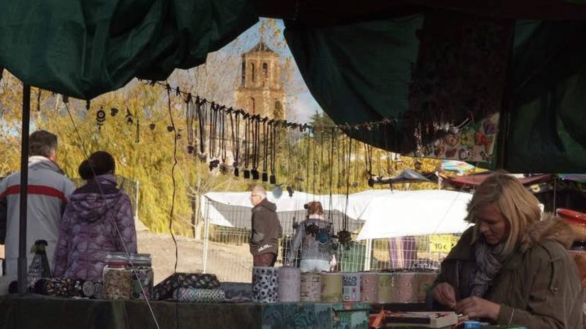 La responsable de un puesto de bisutería trabaja al amparo de la torre de San Benito.