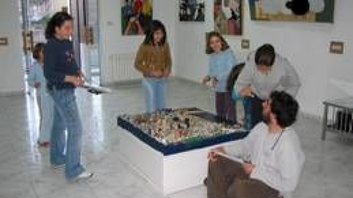 El artista explica a varios niños el significado de una de sus obras expuesta en Astorga