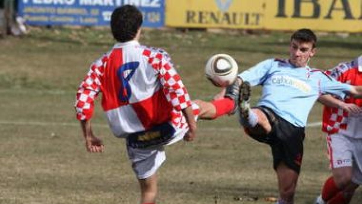 Alberto, de espaldas, disputa un balón con un jugador del equipo vigués.